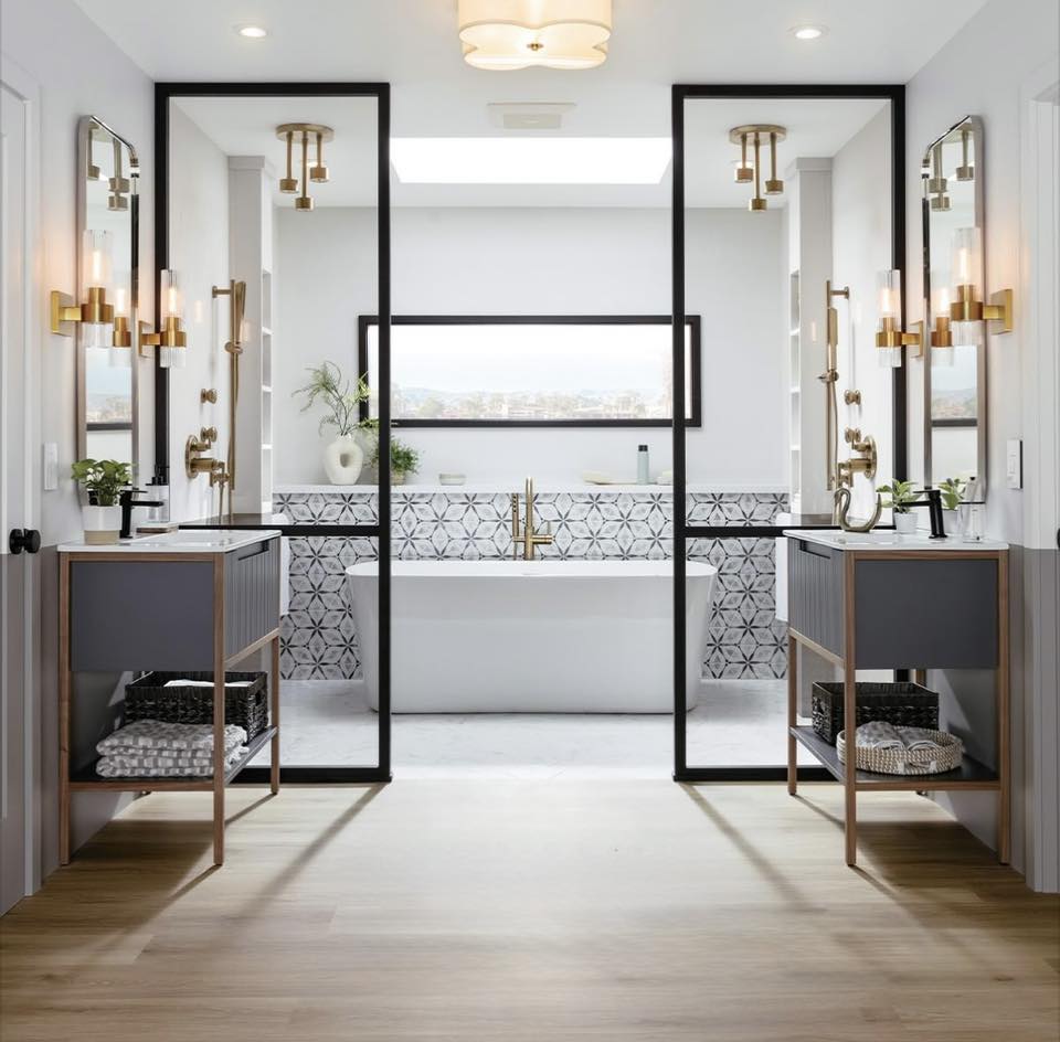 Symmetrical bathroom with freestanding tub and gold fixtures